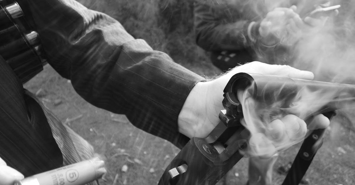Detailed shot of a hand holding a smoking shotgun, highlighting the action and movement.